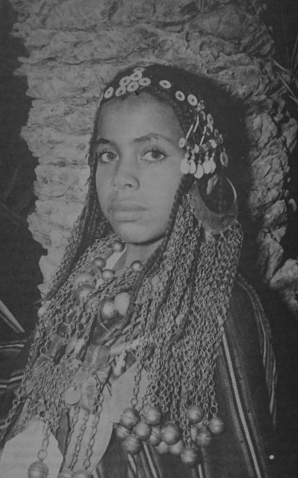 Young Siwa Oasis girl wearing silver neck torques with a sun-disc pendant