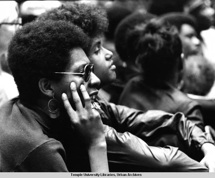 Photograph of two attendees looking onward at a Black Panther Party convention held at Temple University’s McGonigal Hall in Philadelphia. Taken on September 6, 1970 by photographer Salvatore C. DiMarco. No known restrictions on publication.