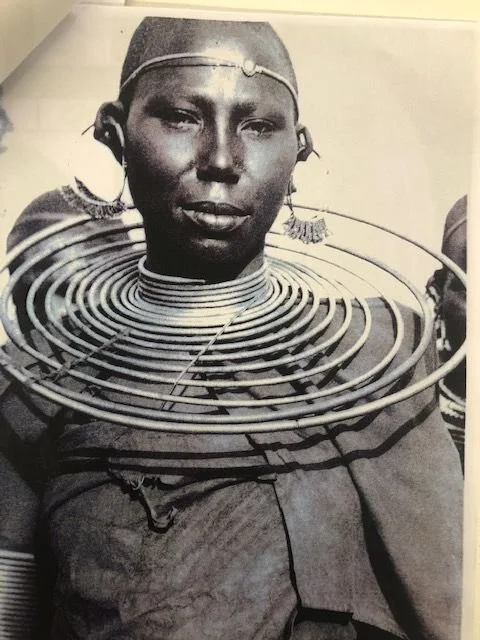 Maasai woman with brass neck coils, traditionally worn to represent wealth, high social status, or a husband's affection. Photographed by S. Skulina in the 1960s, Kenya.