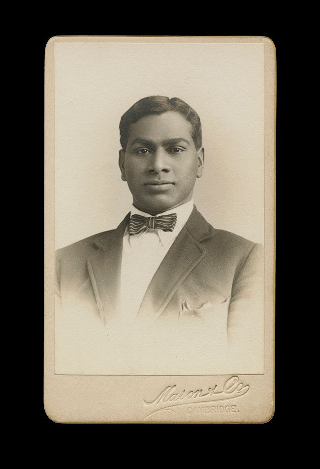 Formal head-and-shoulders portrait of a young Black man in a suit and bow tie, composed with direct gaze.  Photographed by Marion & Co. , Cambridge, England , circa 1890s.