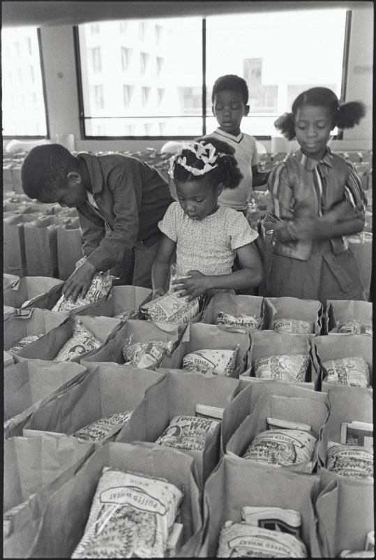 Panther Free Food Program
Children Prepare Bags of Food for Distribution at the Oakland Collesium at the Black Panther Community Survival Conference, Oakland, California, March 1972