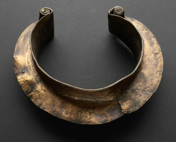 An African cuff choker necklace made out of copper and hammered with curled ends.