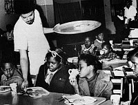 BLACK PANTHERS, 1969.
Kansas City Black Panther Bill Whitfield serves breakfast to local children as part of the Panther free breakfast program, 16 April 1969.