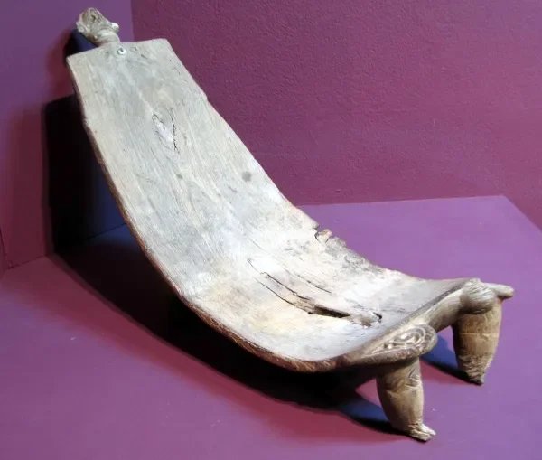 Duho (Ceremonial Seat). Taíno culture; Jamaica, Caribbean. Wood, carved.
This wooden duho (ceremonial seat) features a curved reclining surface supported by carved anthropomorphic legs. Duhos were reserved for caciques (chiefs) and high-status indivi