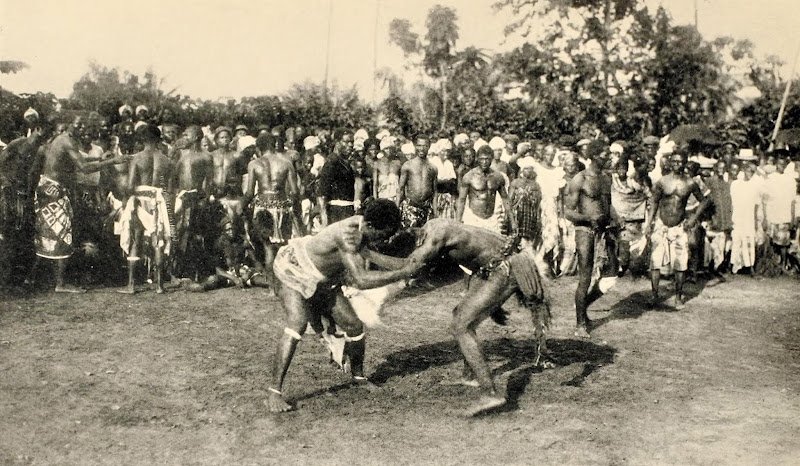 Wrestling at Elele described by P. A. Talbot as "[w]restling to make the yams grow. Chief Eleche's place, Elele" in "Some Nigerian Fertility Cults," 1927.