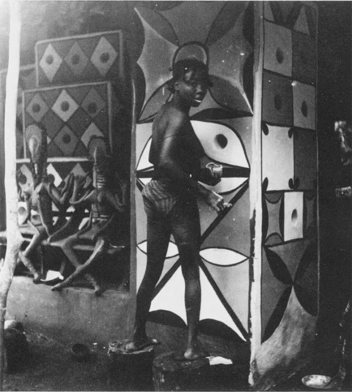 [An Igbo] spirit worker painting the walls of an mbari nearing completion. Note the double Mami Wata images at left. Photo 1930s, [Near Owere]. - Herbert Cole, 1988.
