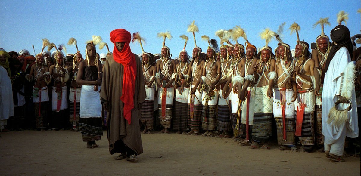 At the Gerewol festival, a Wodaabe maiden coyly reviews the contestants to choose a winner. Photographed 1997 in Niger.