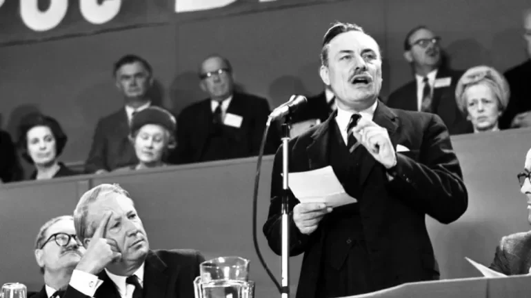 Edward Heath, leader of the Conservative Party, listens as Enoch Powell, right, addresses delegates during the session of the annual Conservative Party Conference in Brighton, England on October 19, 1967 [AP Photo/ Harris]