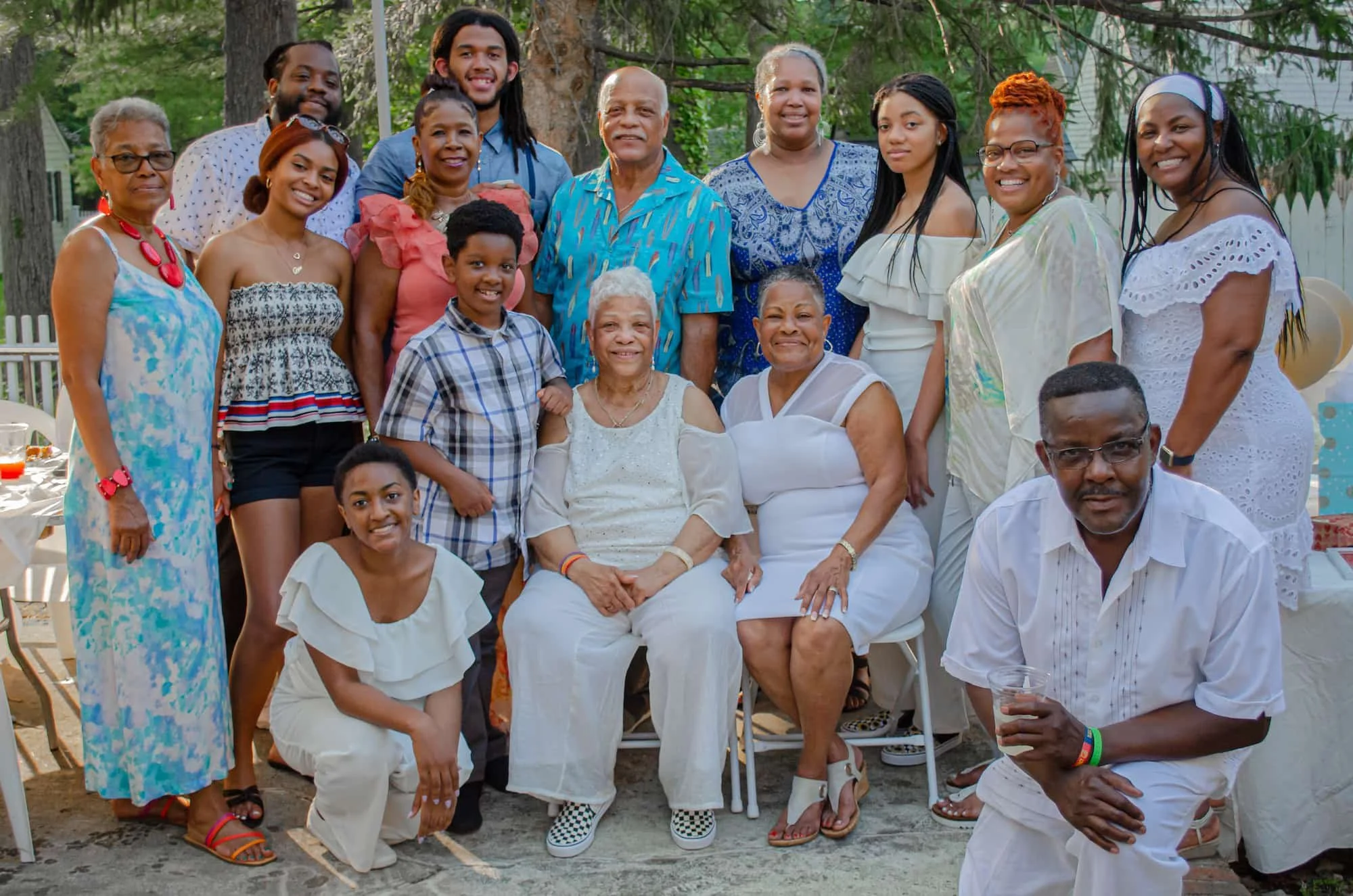 A group of people gathered and smiling in casual clothing outdoors
