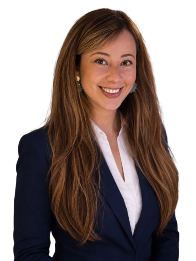Professional woman with long, wavy light brown hair wearing a navy blazer and white blouse, smiling at the camera.
