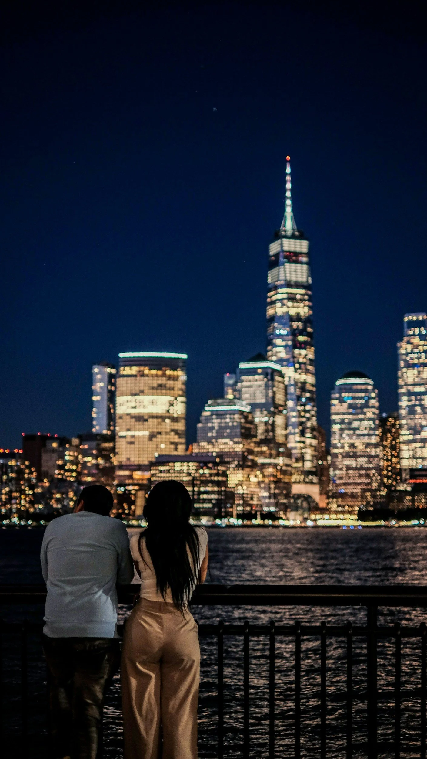 Asian American Couples facing the Manhattan NYC skyline at night after their therapy sessions with a couples therapist