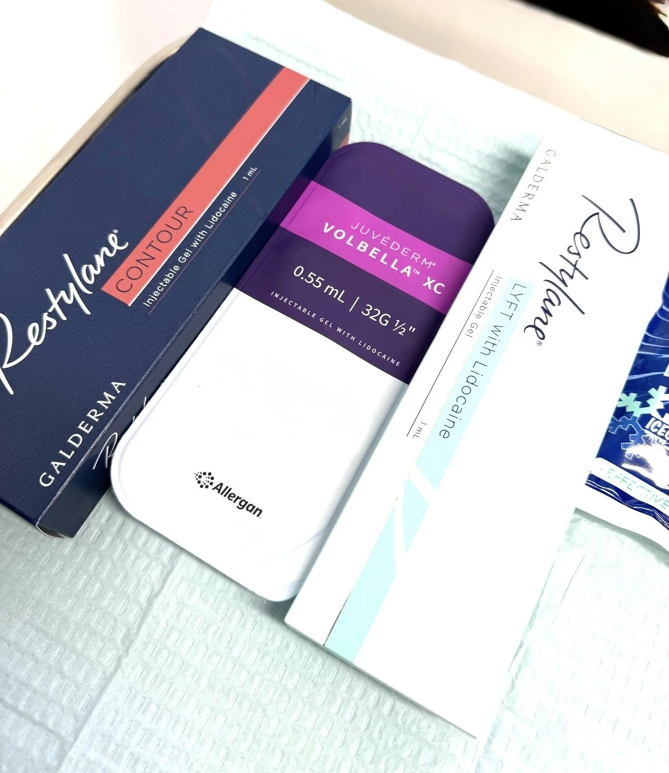 Boxes of Restylane and Juvéderm dermal fillers on a treatment tray