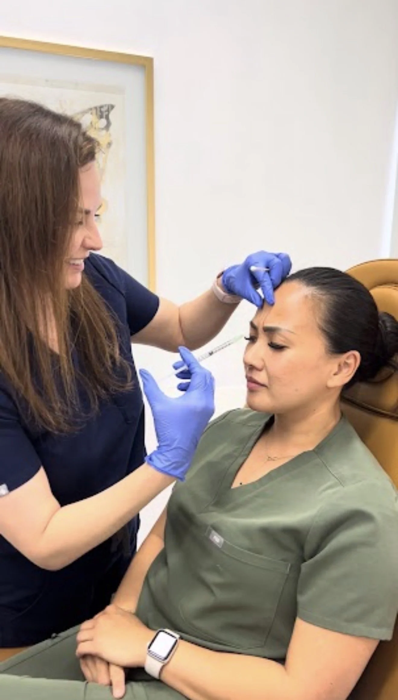 Dr. Lina Kennedy injecting Botox into a patient's forehead in the treatment room at Grace Dermatology