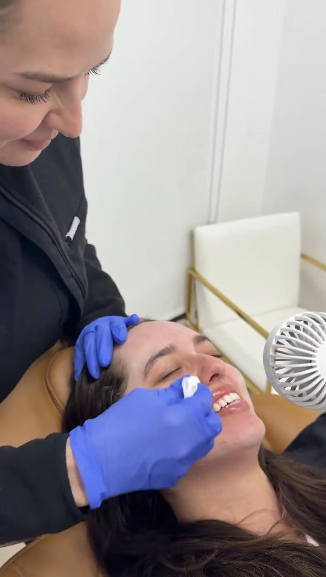 Dr. Lina Kennedy applying a chemical peel to a reclining patient's face at Grace Dermatology