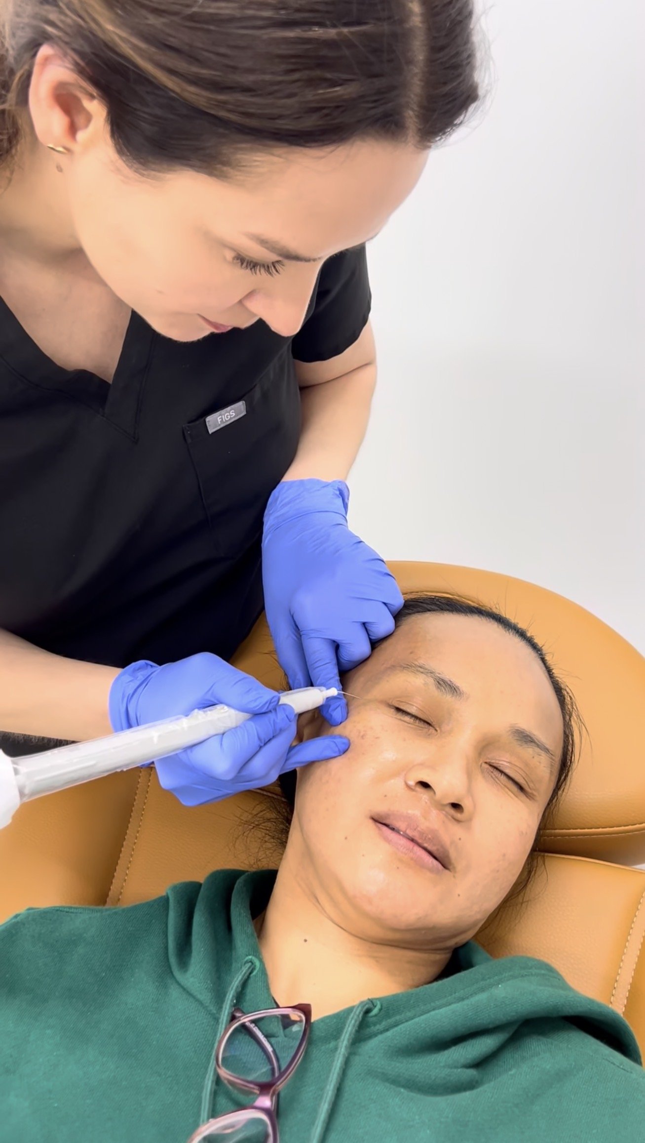 Dr. Lina Kennedy using an electrocautery pen to remove a small benign lesion at the outer corner of a patient's eye