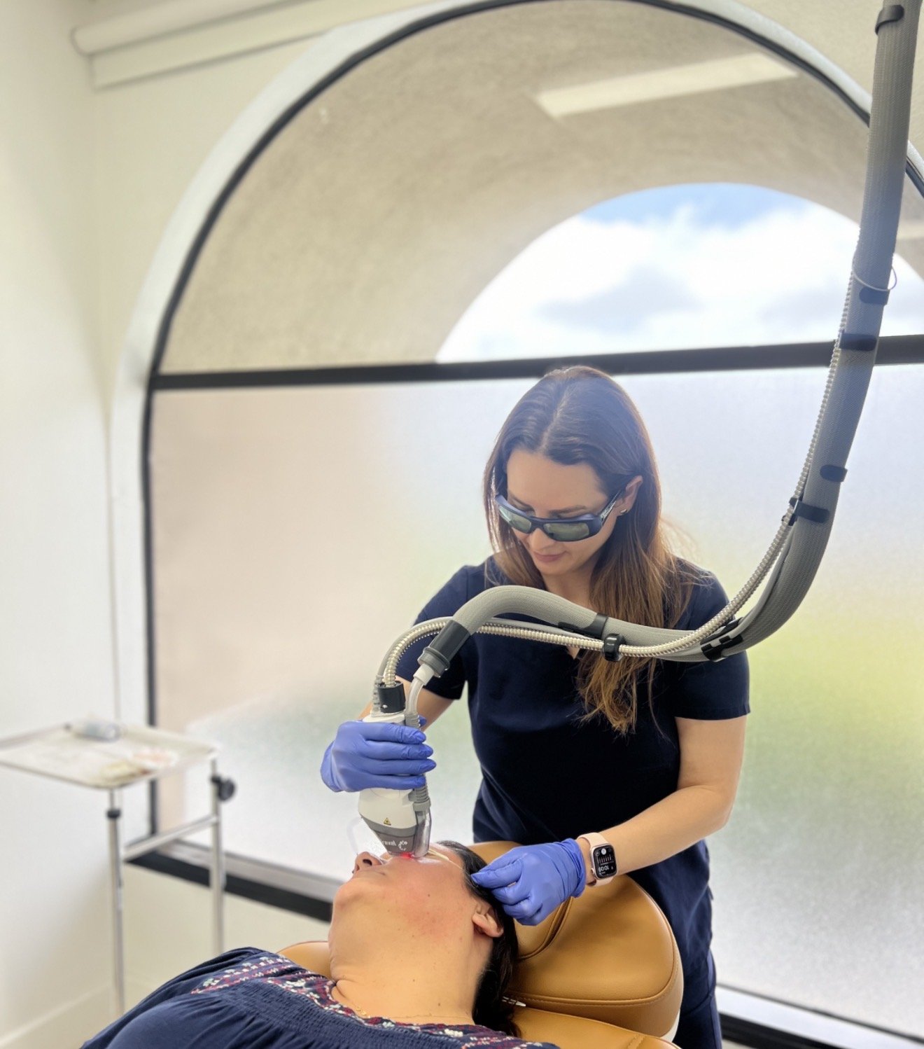 Dr. Lina Kennedy in protective eyewear performing a Fraxel Dual laser treatment at Grace Dermatology