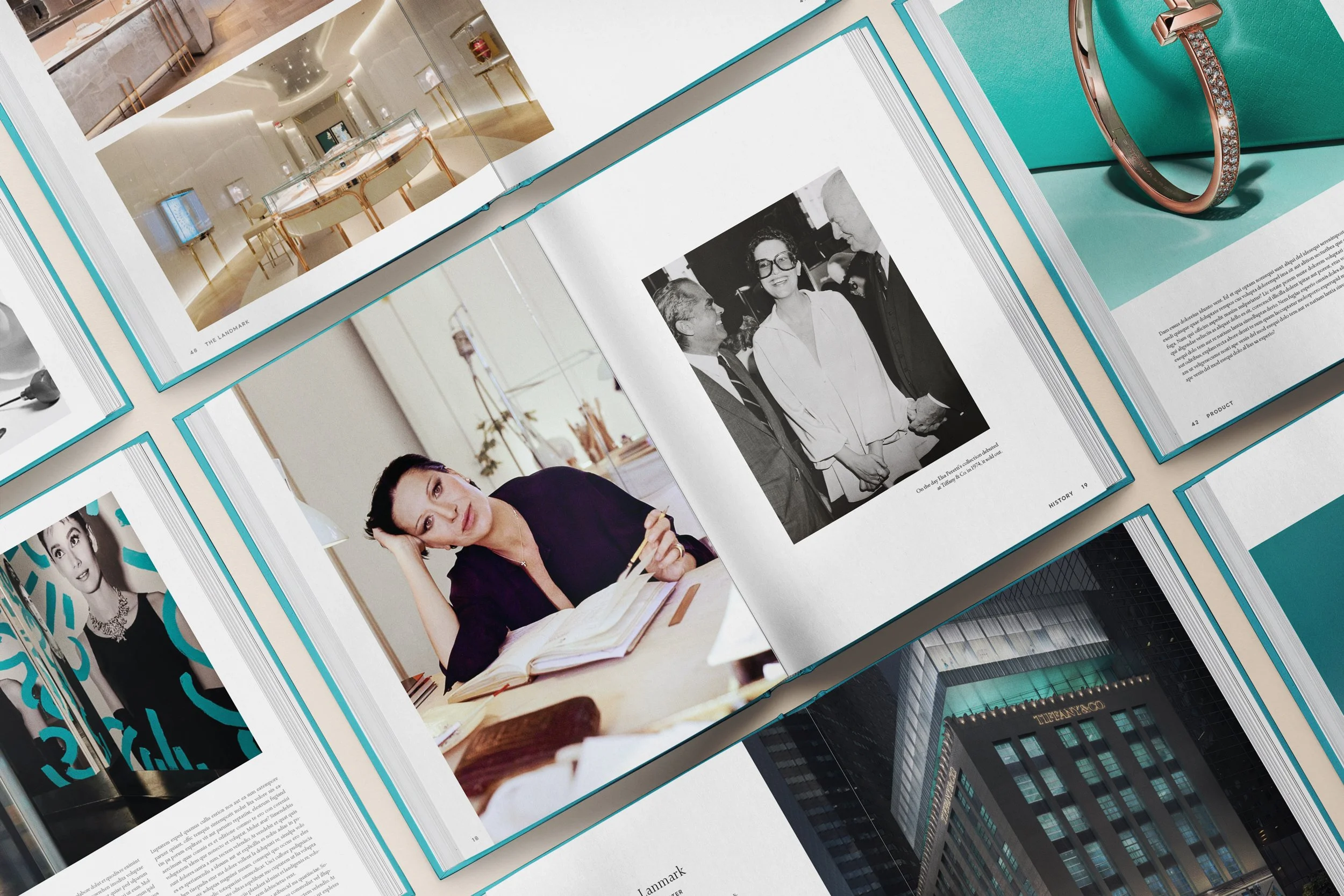 Open magazine displaying photographs of jewelry, people, and buildings, including a woman working at a desk and a ring on a teal background.