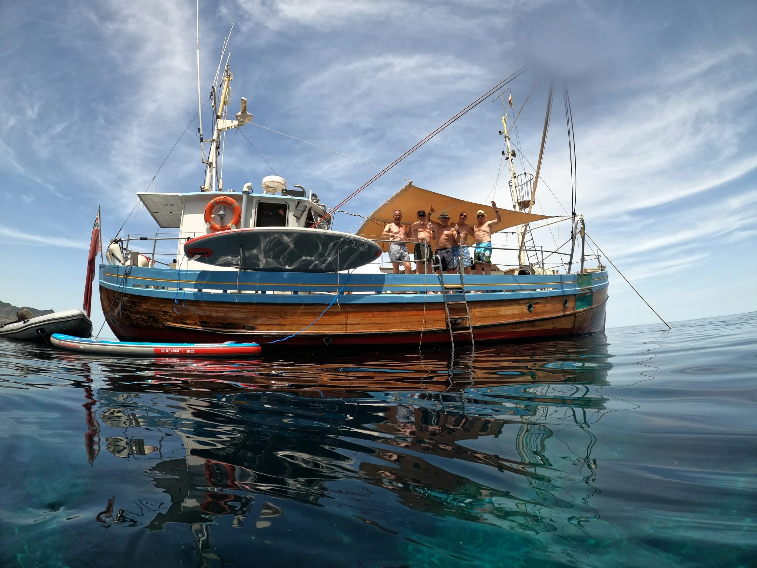 Classic boat with paddleboards at anchor