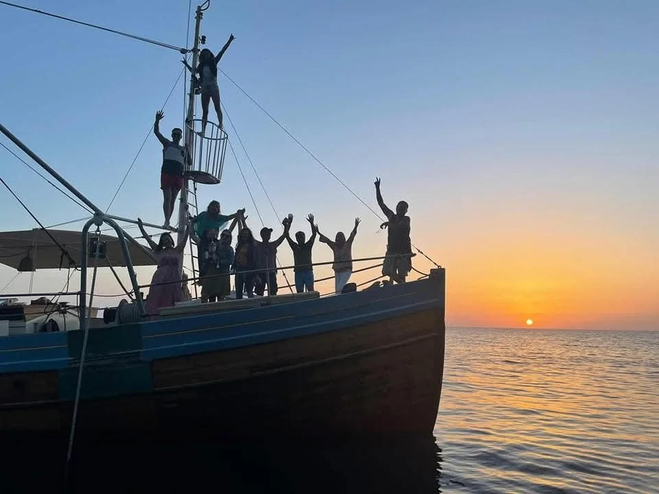 Guests celebrating in rigging at sunset