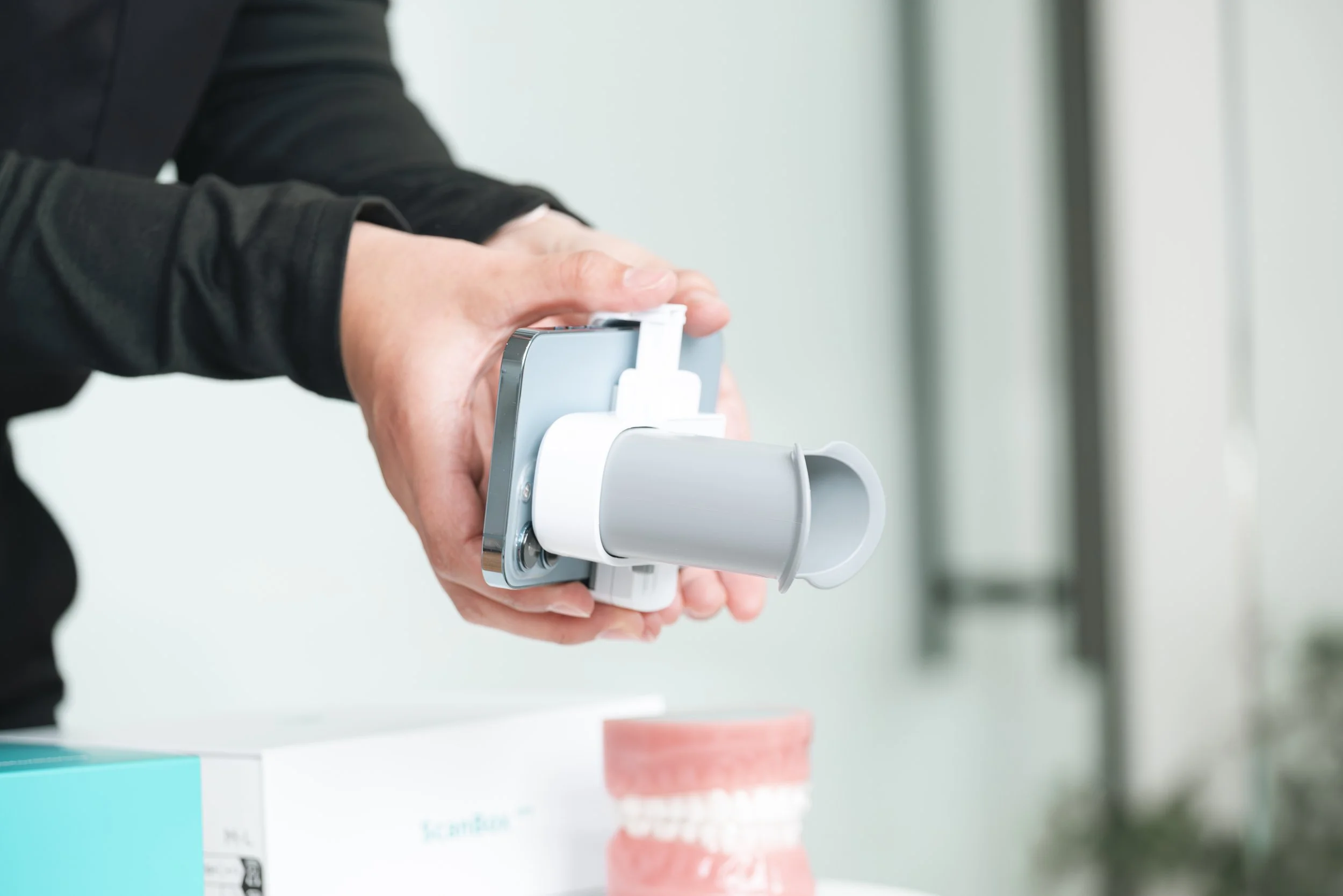 Patient utilisant le Scanbox avec son téléphone pour un suivi orthodontique à la maison