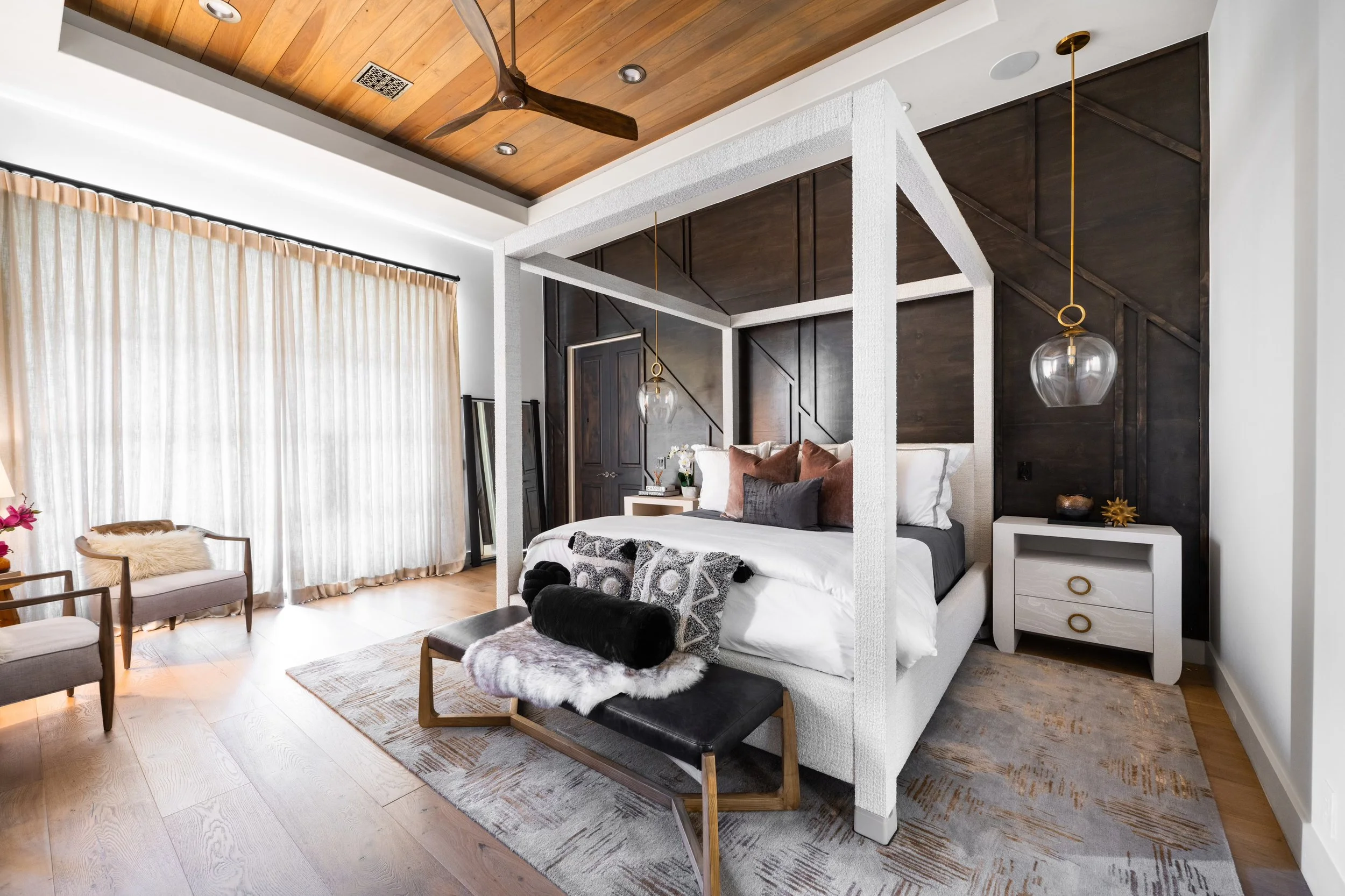 Modern bedroom with canopy bed, wood ceiling, and elegant furnishings