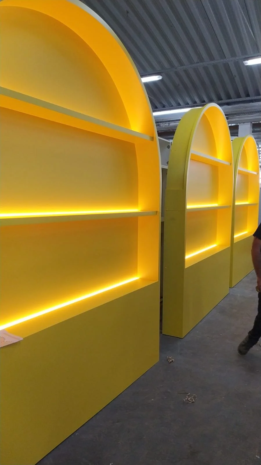 Rayonnages jaunes avec éclairage lumineux dans un espace industriel ou commercial.