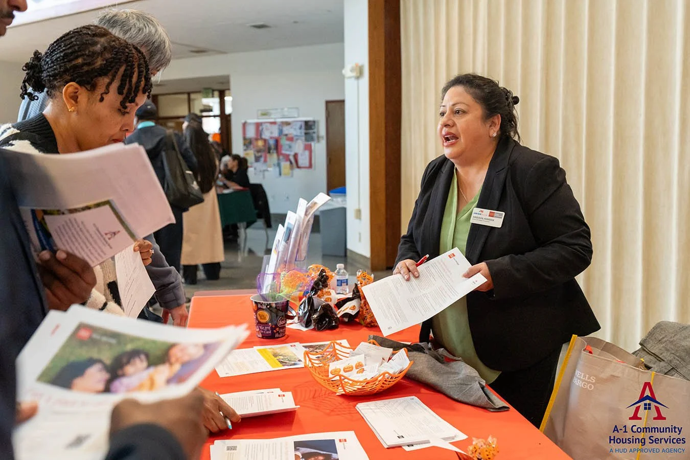 event-booth-with-wells-fargo-home-mortgage-consultant-talking-to-community-members-interested-in-information.jpg