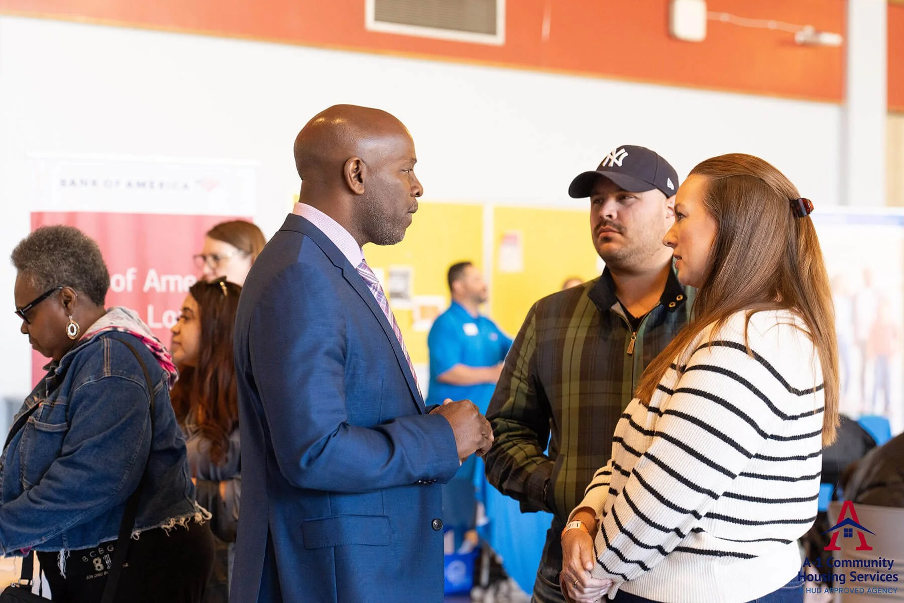 man-in-blue-suit-talking-to-a-couple-near-vendor-tables.jpg
