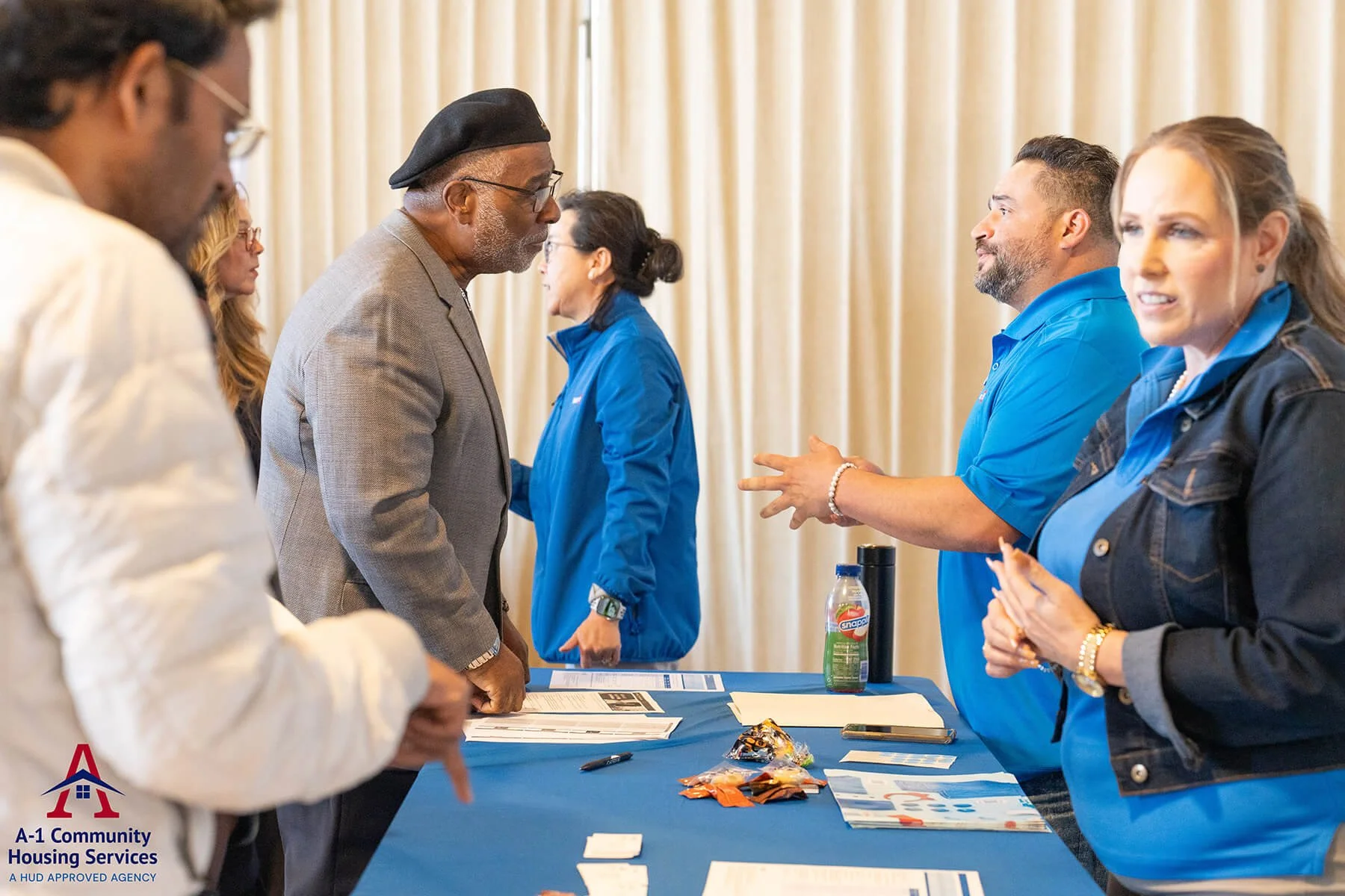housing-experts-wearing-blue-shirts-talking-to-community-members.jpg