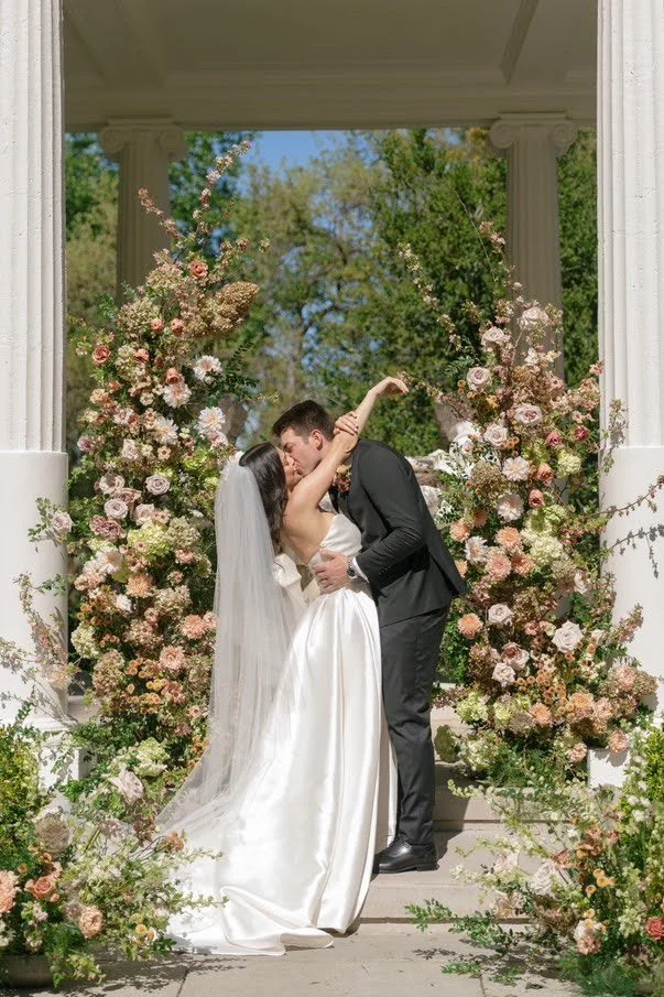 Bride and groom dancing beneath large floral installations at Villa Montalvo wedding venue in Saratoga California, florals by Petal and Salt Floral