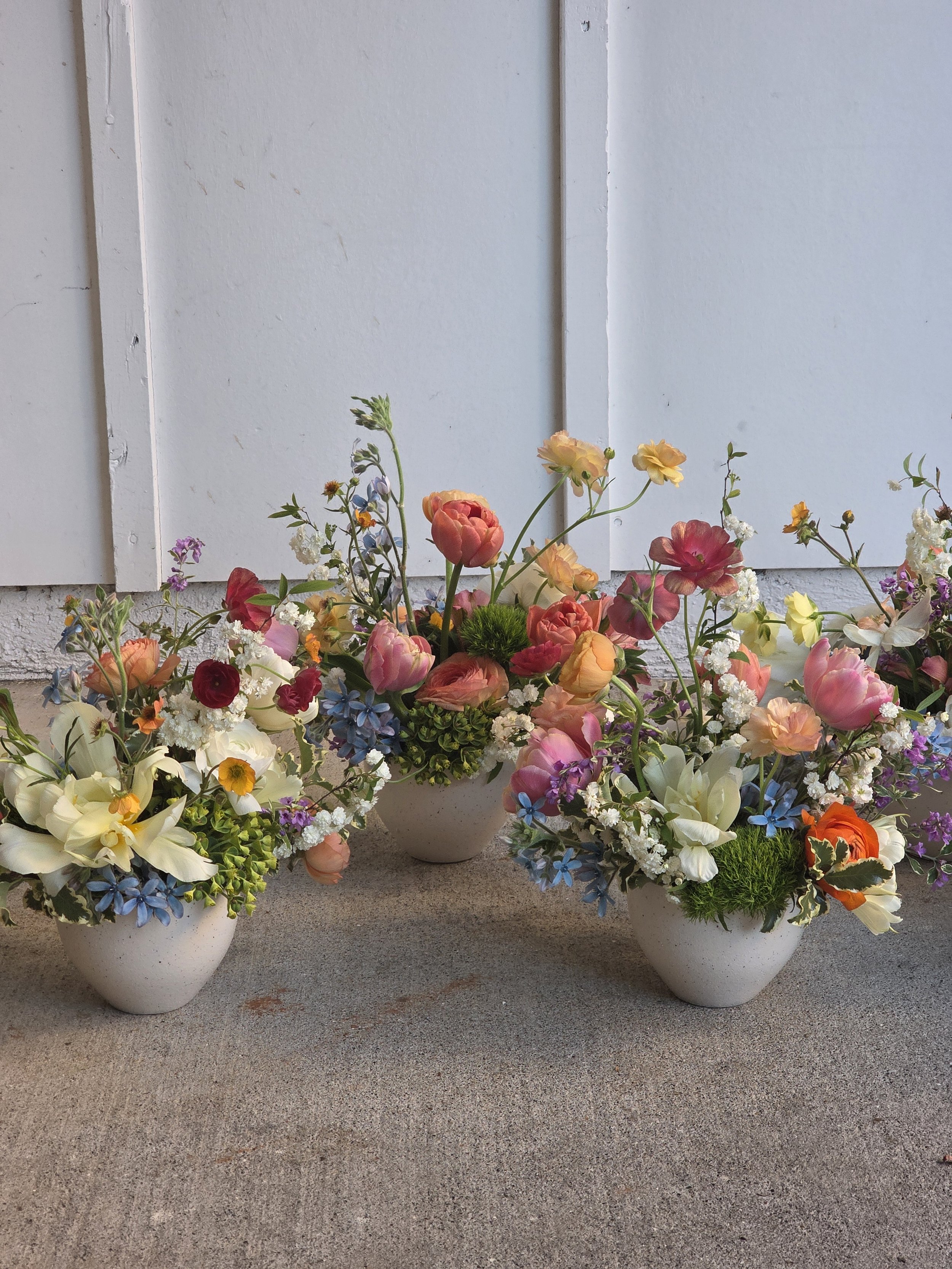 Three white ceramic vessels with colorful mixed garden florals, Bay Area event florist Petal + Salt