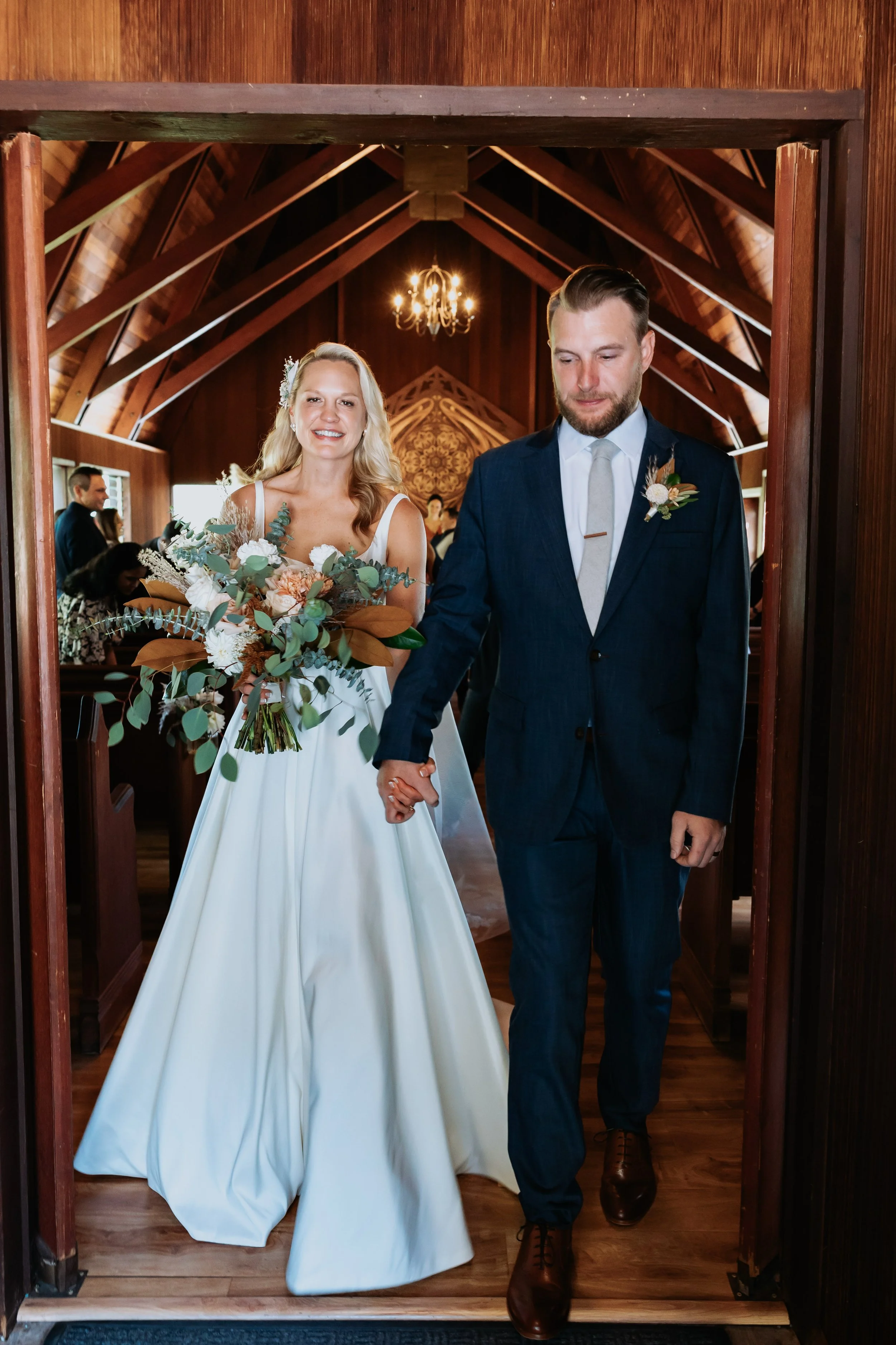 Bride with lush bridal bouquet, bohemian fall focused florals and greenery at their wedding ceremony at Chapel on the Hill in Los Gatos, California. 