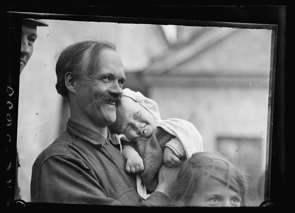 male refugee ancestor smiles to reach safe place with his young daughters