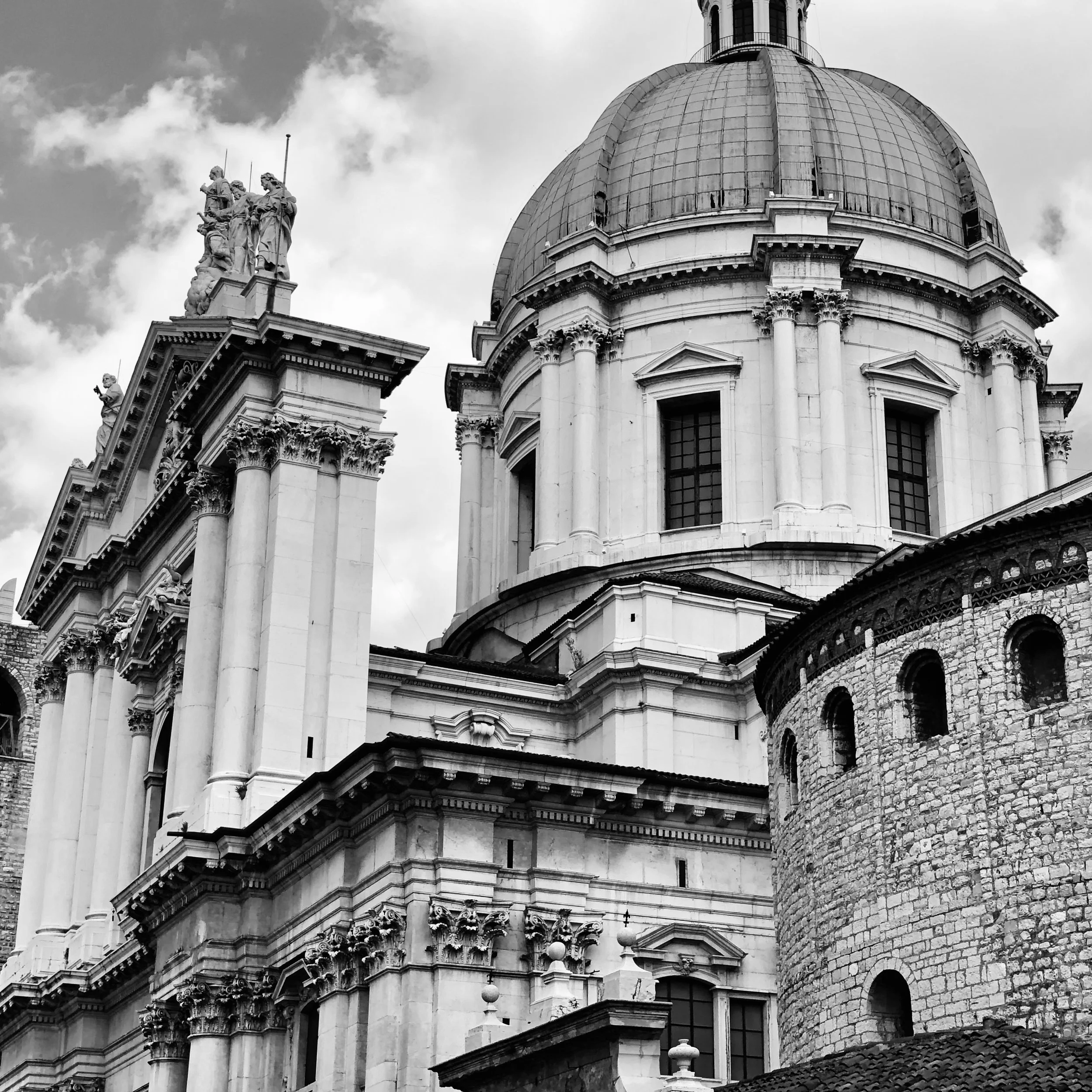 Black and white photograph of a historic European church with a large domed roof, ornate columns, and intricate architectural details.