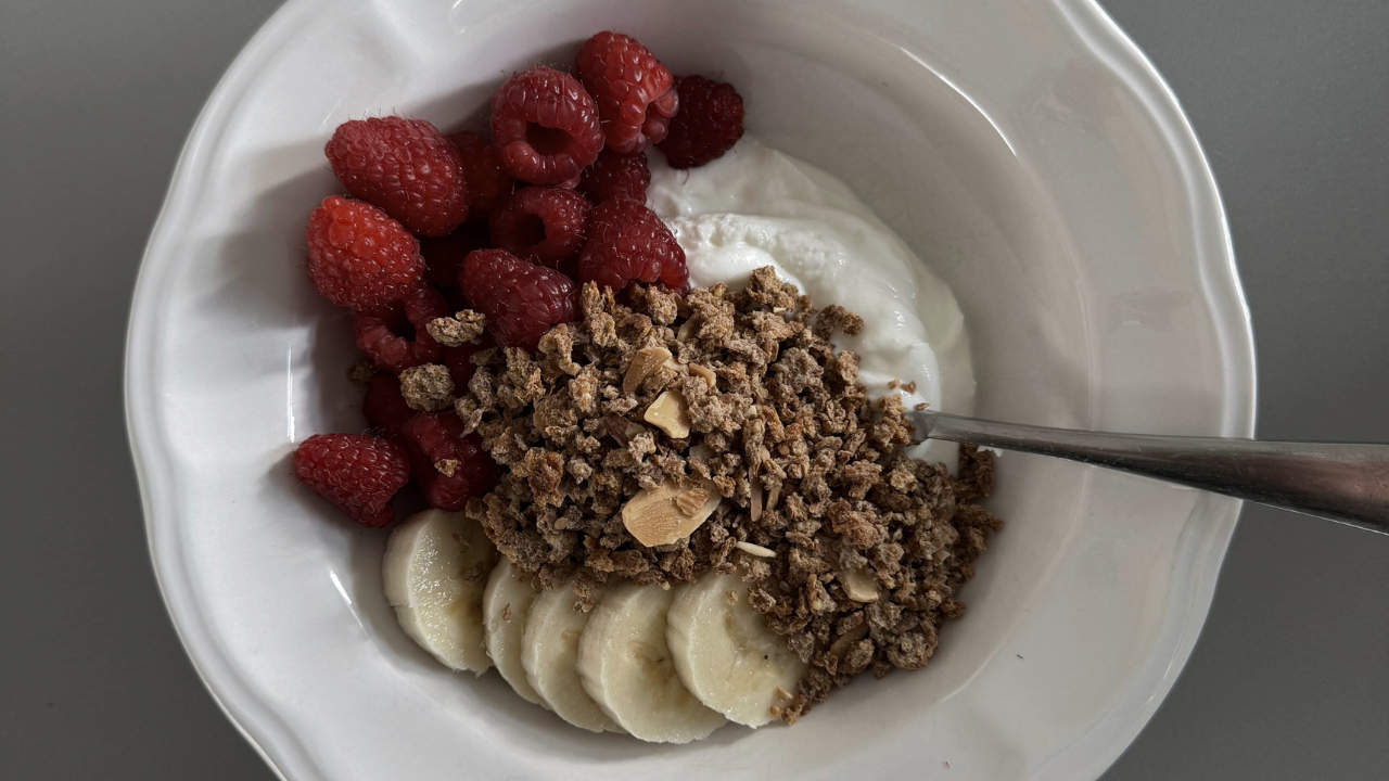 bol avec yogourt, céréales, bananes et framboises