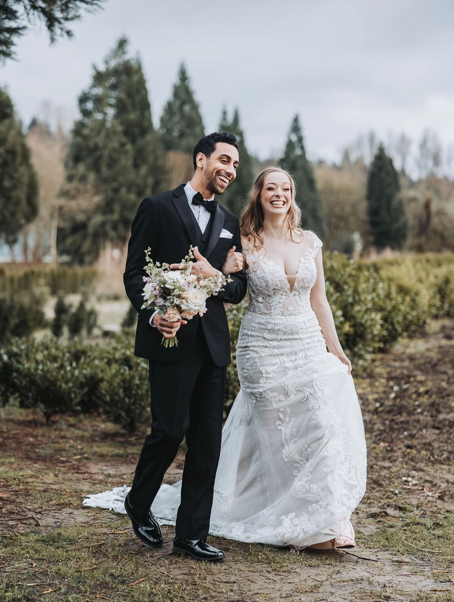 Bride and Groom walking down the a Nursery witha beautiful field behind them