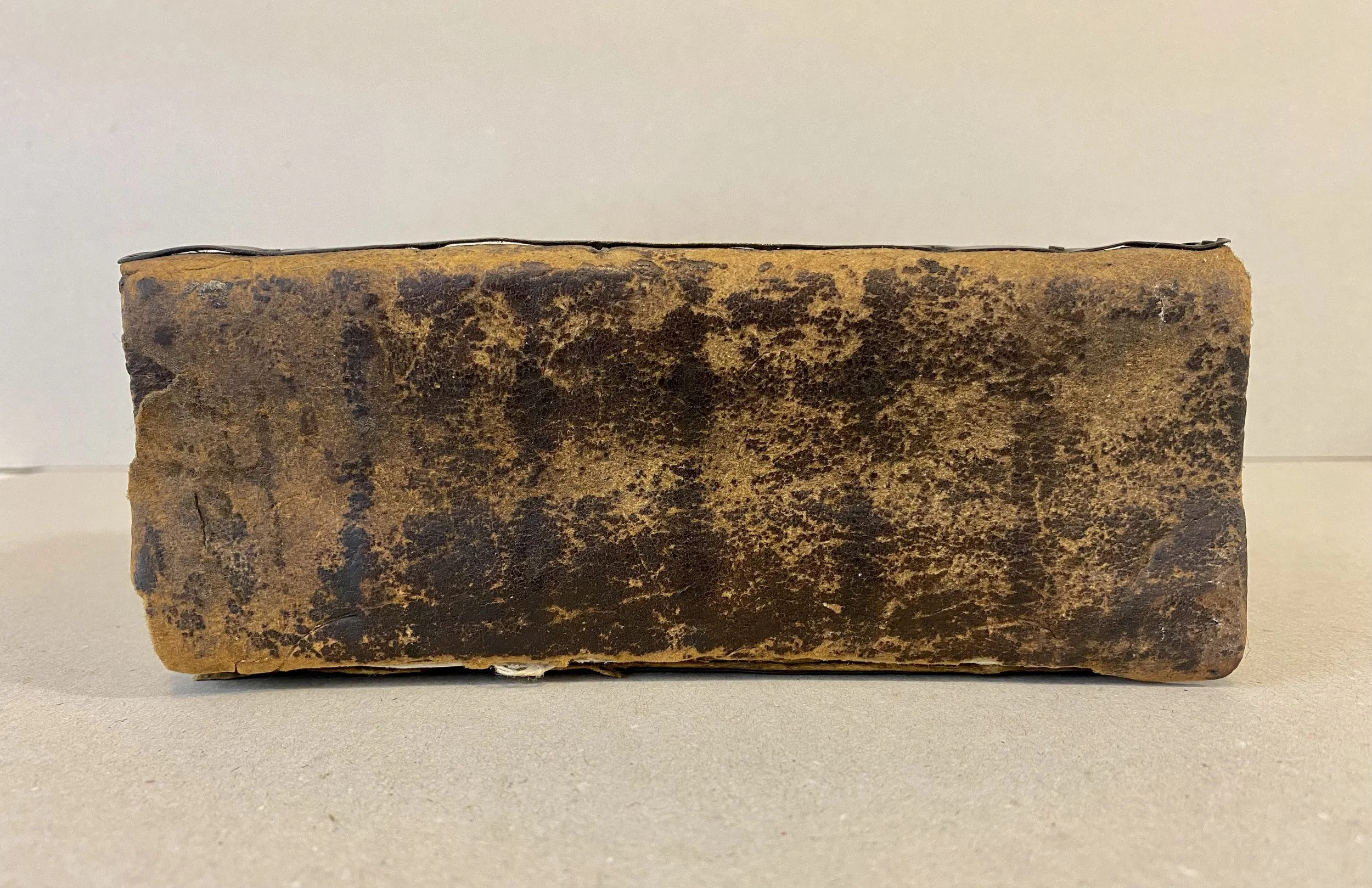 Damaged and aged brown leather spine of 18th century bible