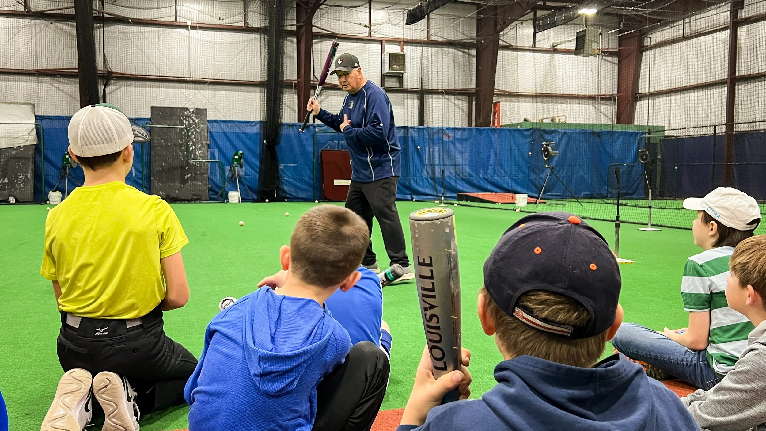 Coach working with young baseball players