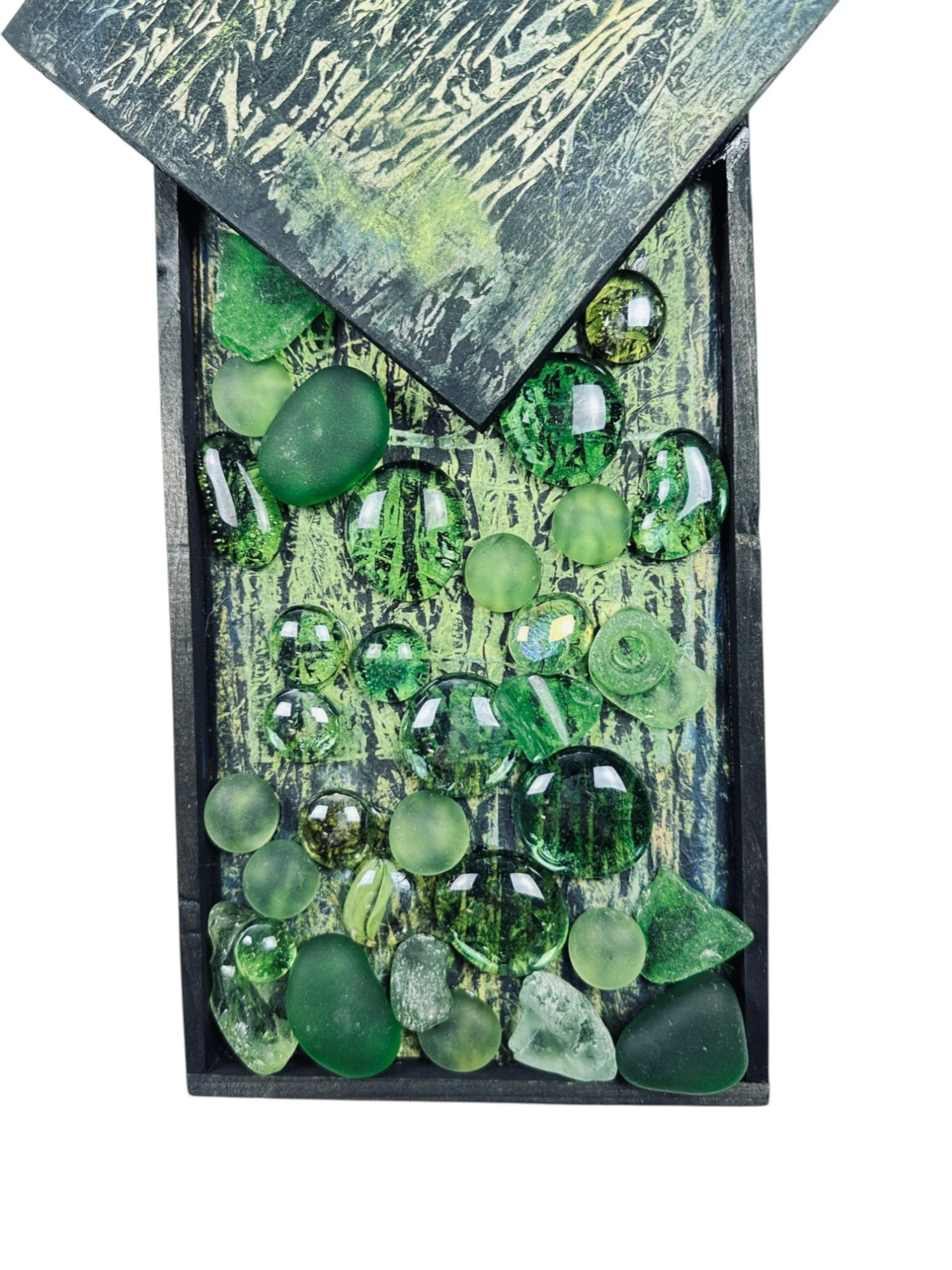 Detail close-up of lower portion highlighting smooth and frosted green glass fragments against textured background
