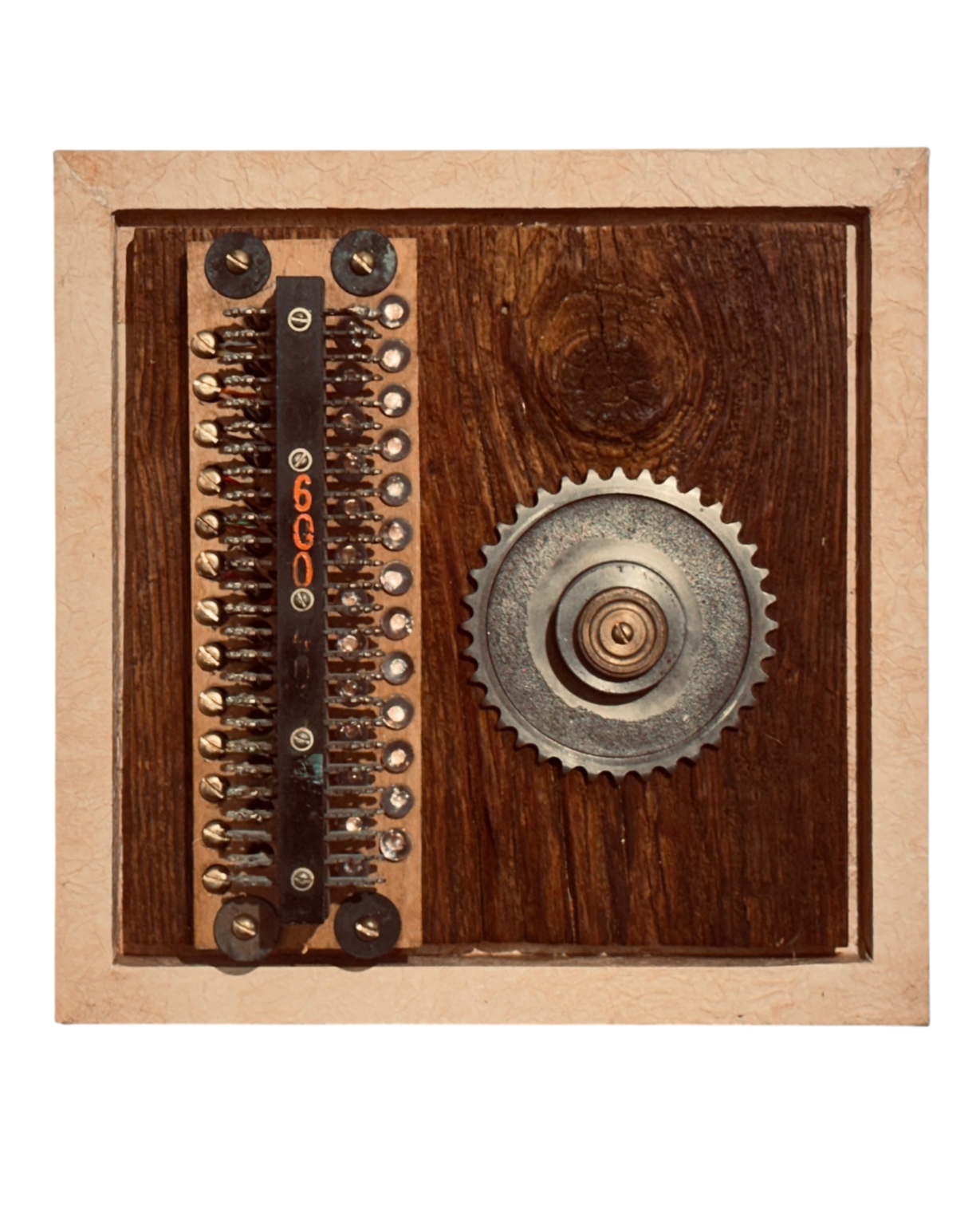 Minimal assemblage artwork featuring vintage electronic components beside a steel gear mounted on reclaimed wood.