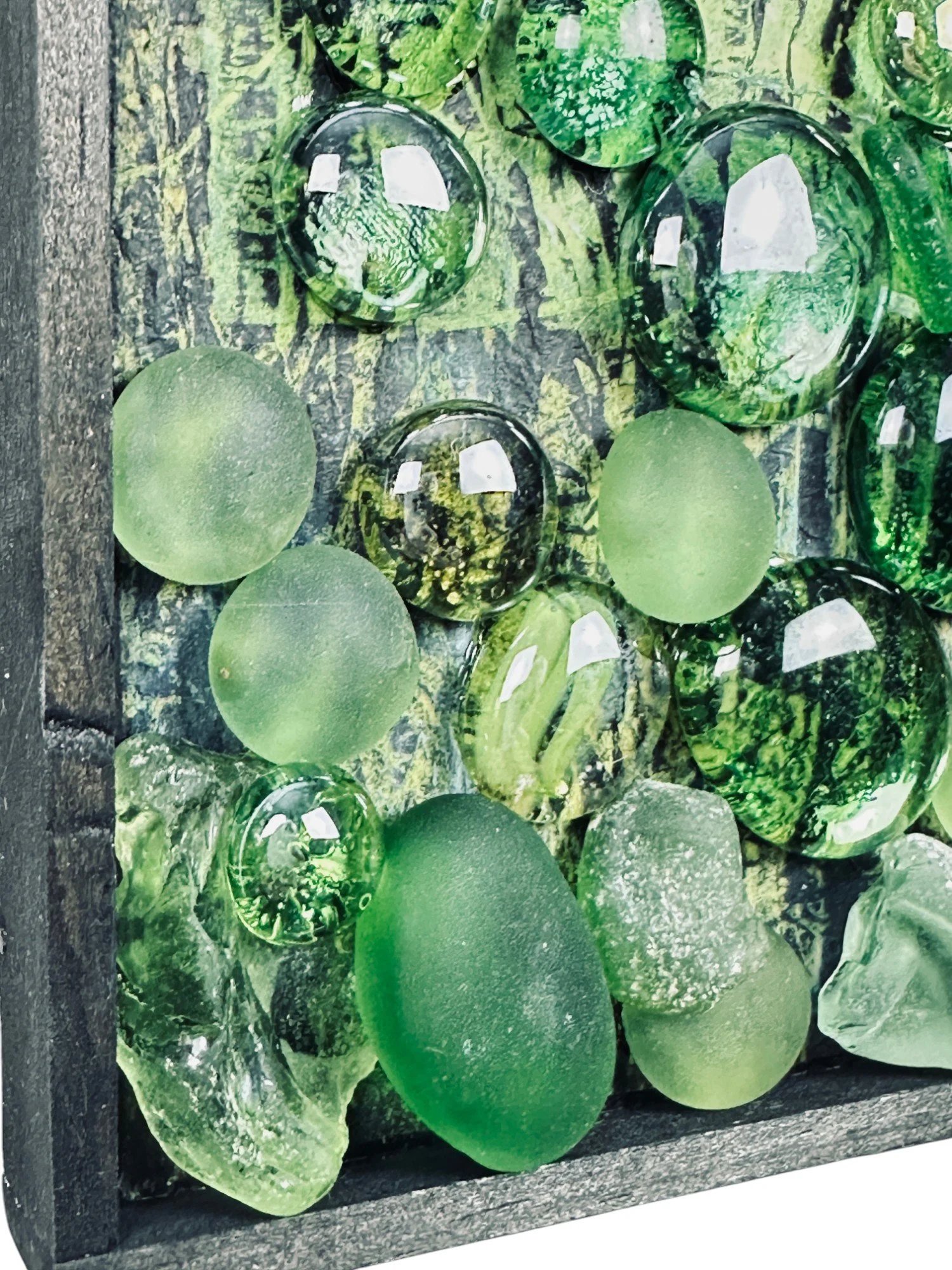 Extreme close-up of left side glass cluster with textured surface and translucent green shapes