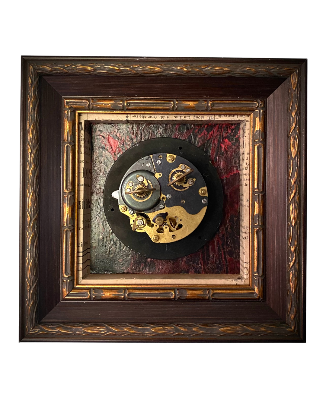 IAssemblage artwork featuring a vintage clock movement mounted against textured red and black surfaces within a shadow box frame.