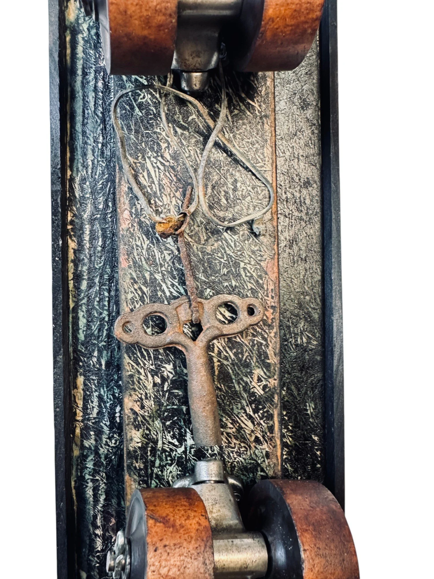 Midsection view showing embedded skate wheel, surrounding dark wood texture, and the looped skate key placement