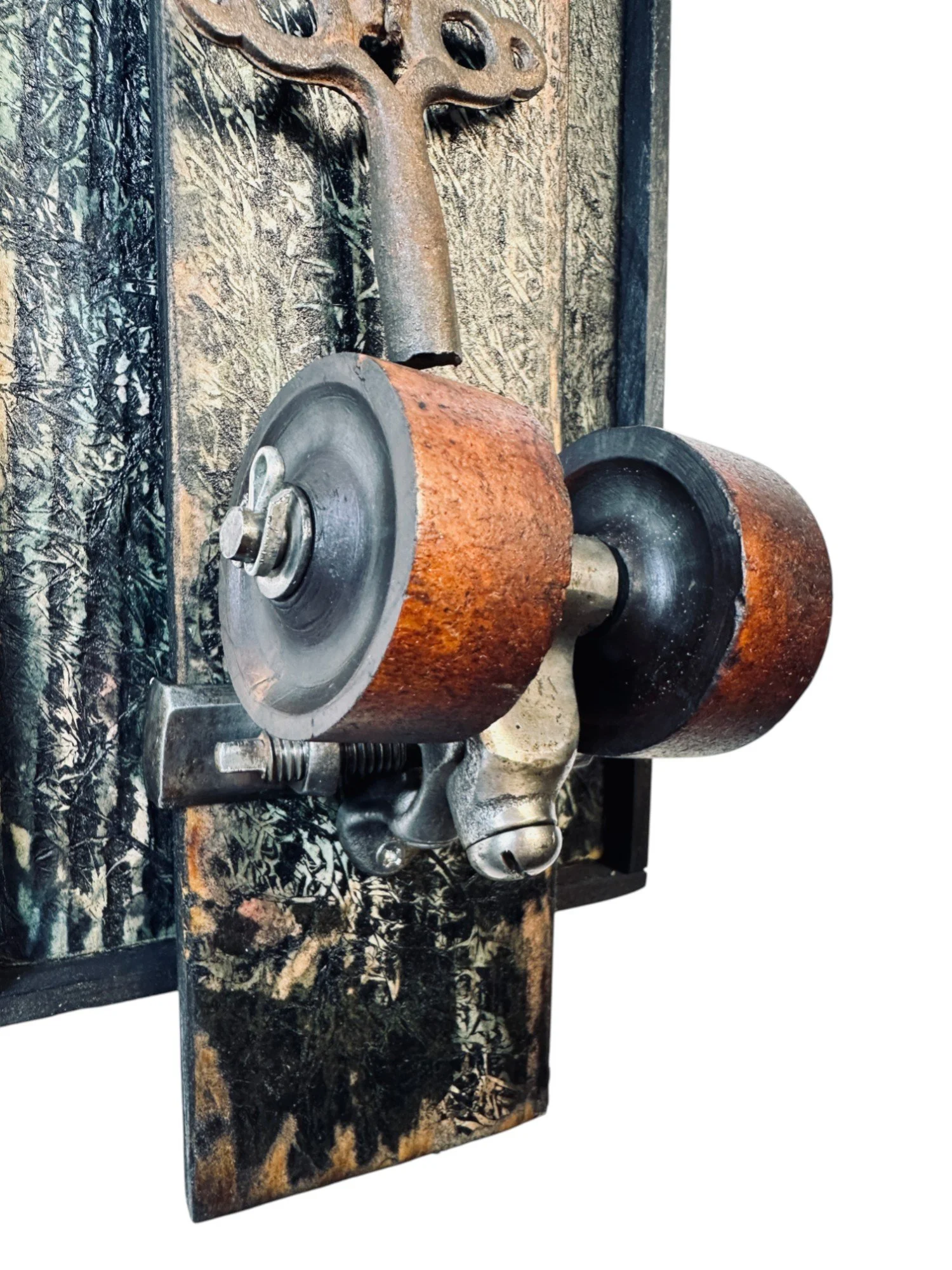 Detail of mounted vintage roller skate wheel and attached skate key with wire, highlighting aged texture and metal hardware