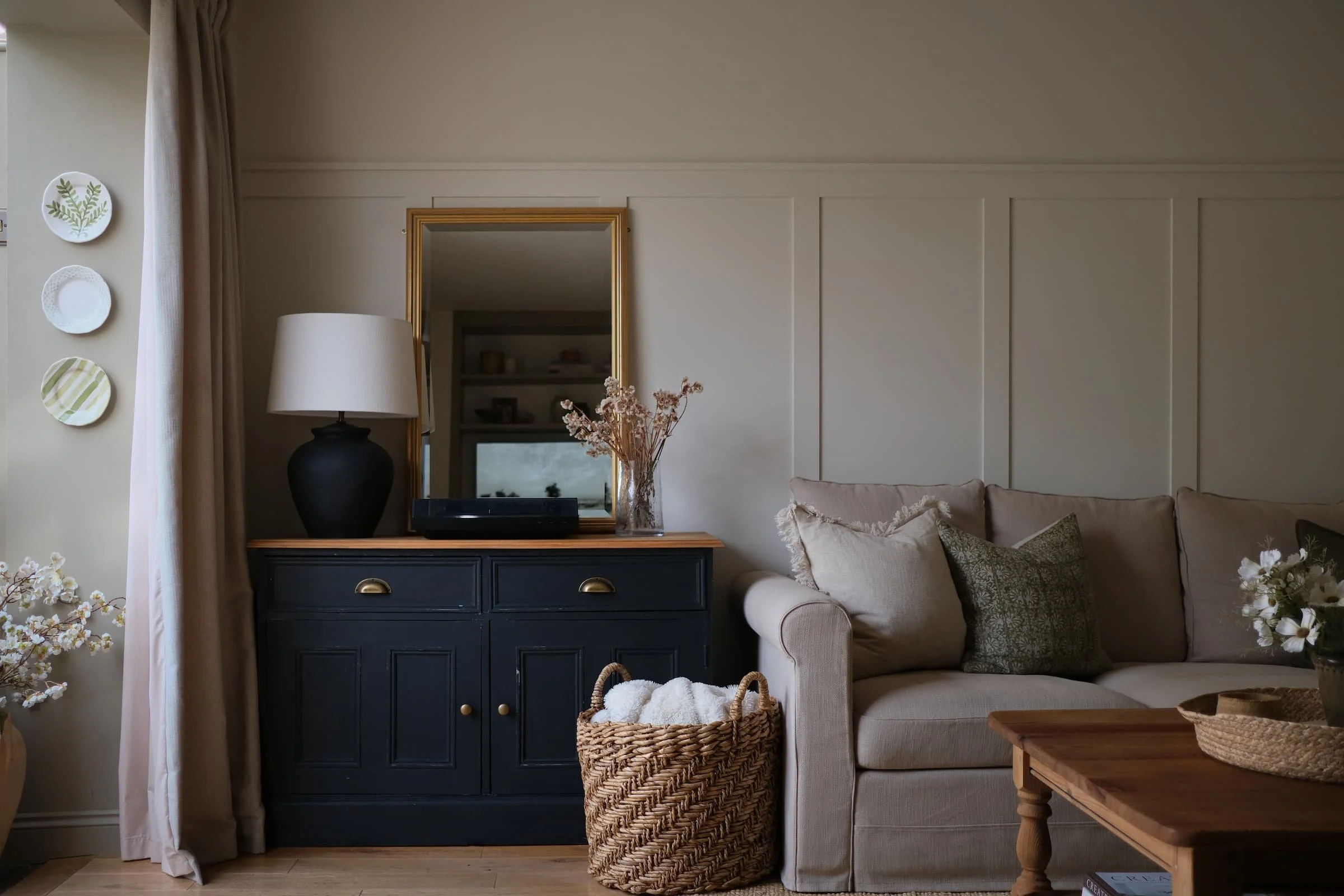 Cosy Cotswolds living room design featuring a dark painted sideboard, neutral sofa, and layered textures — showcasing Amy Broad Interiors’ timeless interior styling.