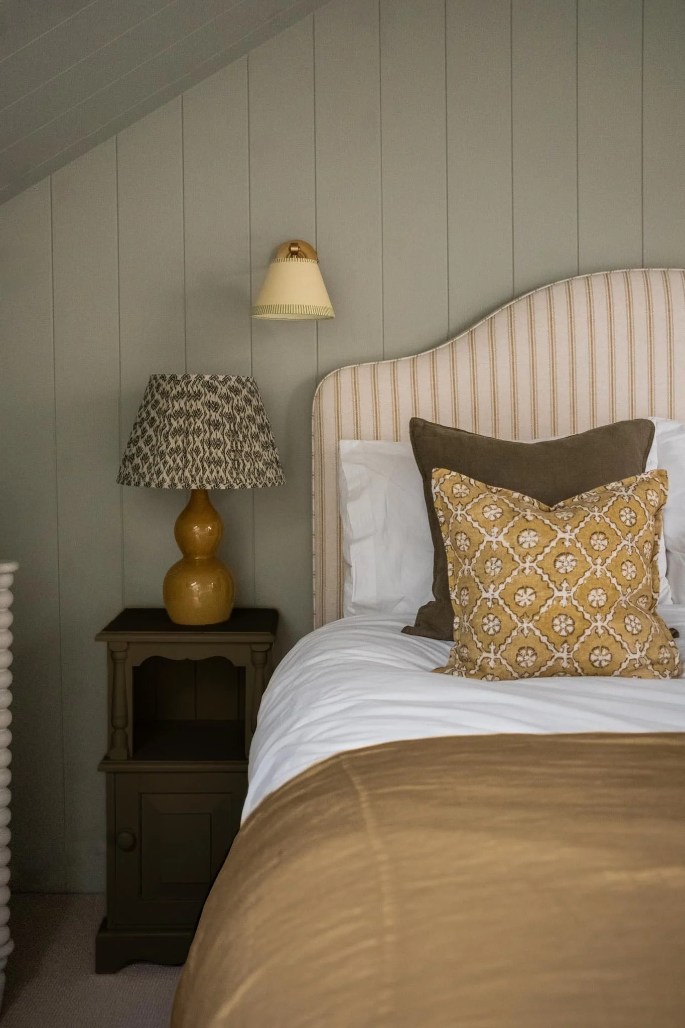 Elegant Hampshire bedroom with panelled walls, layered linens, and warm brass accents — designed by Amy Broad Interior Design.