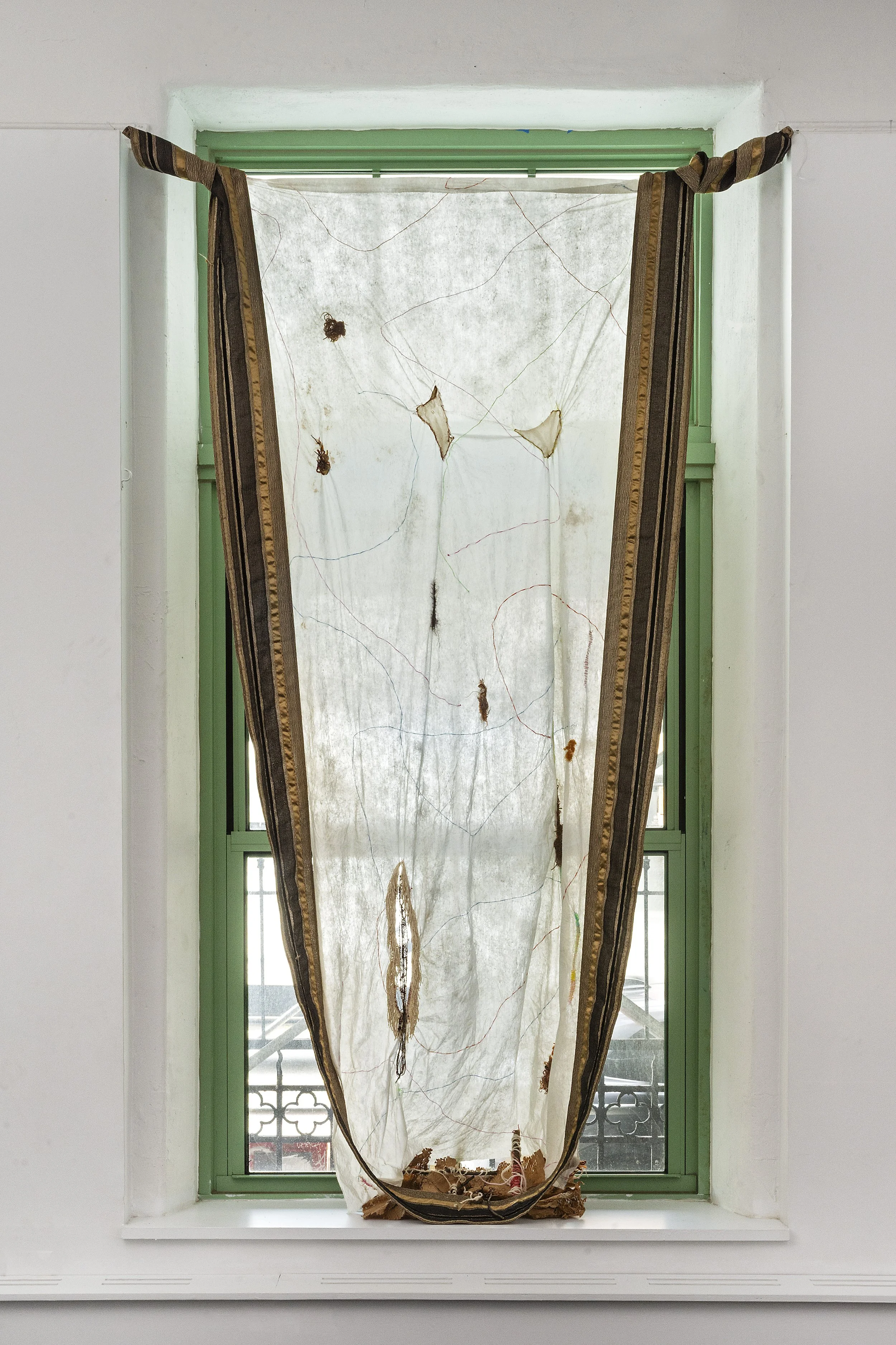 Yasmeen Abdallah,
Glacial, 2025, Embroidery and picnic remnants with dirt on fabric with trim, 10 ft x 3 ft.