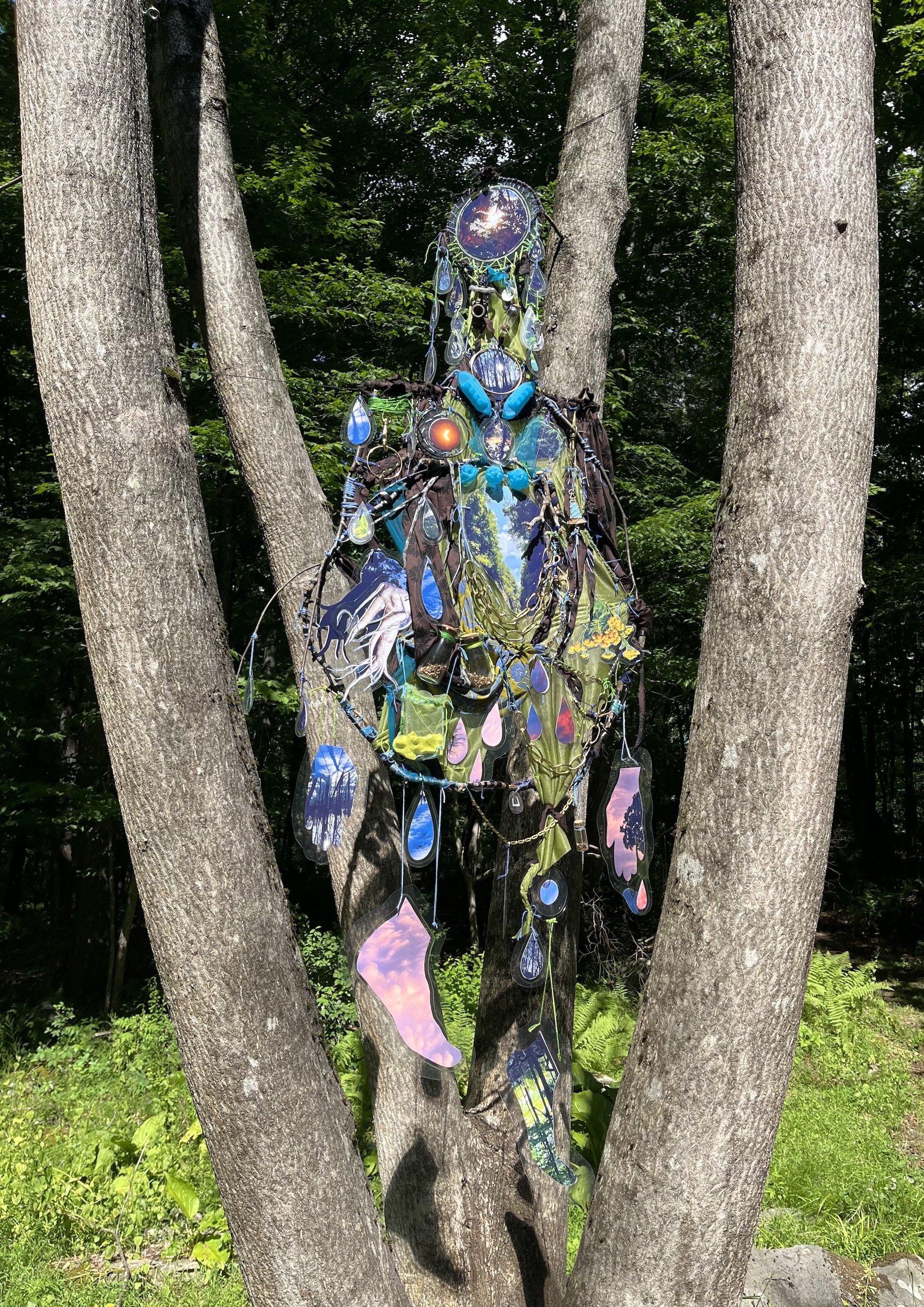 2026, Laminated digital prints of the Hudson Valley landscape, mandrake root, embroidery thread, chains, branches, jars, ceramics, fabrics, assorted found objects (natural & human made), 82 x 26 x 3 inches

Installed at "In ter/situ," a site-responsi