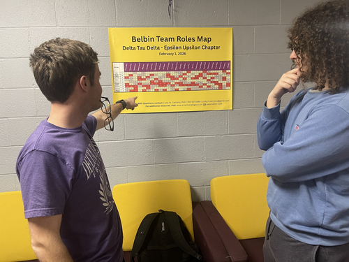 Delts discuss the team map poster hanging in the Delt Shelter.