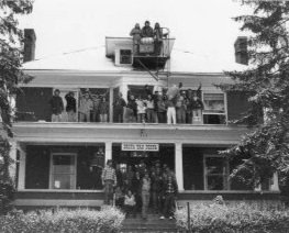 The brothers of the Delta Tau Delta Chapter at Marietta College stand on the porch, the roof, and fire escape of 507 Putnam Street.